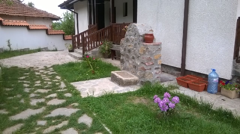 Цветя и каменна чешма край верандата